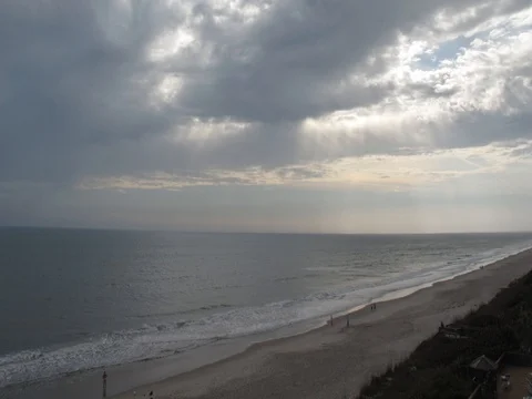 Time lapse of clouds and sun rays passing by over beach coastline Stock Footage 82052217