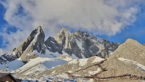 Time-lapse of clouds and tourists at a majestic snow mountain peak. Stock Footage 328684622