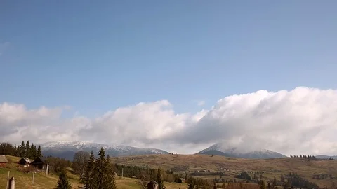 Time lapse clouds are moving quickly wrap snow-capped mountains and then fill Stock Footage 77007076