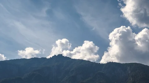 Time lapse clouds behind mountains with hotel on hilltop Stock Footage 120989234
