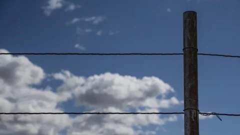 Time lapse of clouds beyond a ranch fence Stock Footage 118658640