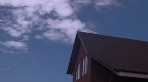 Time-lapse clouds in blue sky over roof of the brown house Stock Footage 62973433