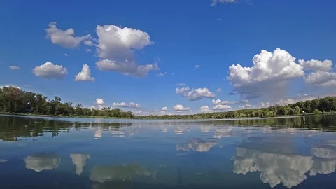 Time lapse of clouds on a blue sky over a lake at sunny summer day. Stock Footage 112979933