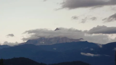 Time-lapse of clouds churning over a mountain peak at sunset. Stock Footage 57514911