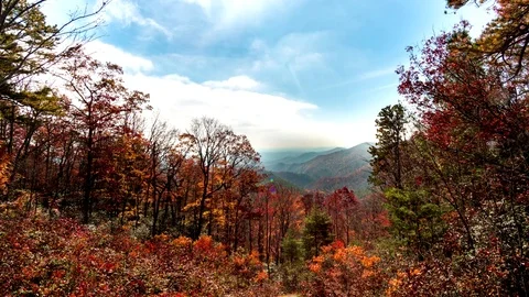 Time lapse of clouds clearing over the fall foliage in the mountains Video stock 83782823