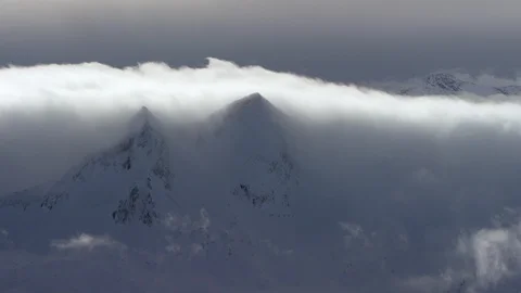 Time-lapse of clouds covering beautiful snow capped mountains during winter Stock Footage 116742502