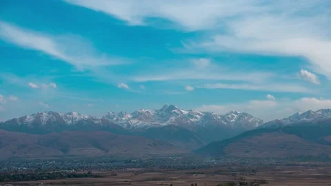 Time lapse of clouds drifting over scenery snowy mountain peaks Vídeo Stock 220659629