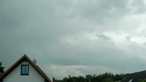 Time lapse. Clouds float over the roof of an apartment building before Stock Footage 221555249