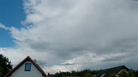 Time lapse. Clouds float over the roof of an apartment building before Stock Footage 221555260