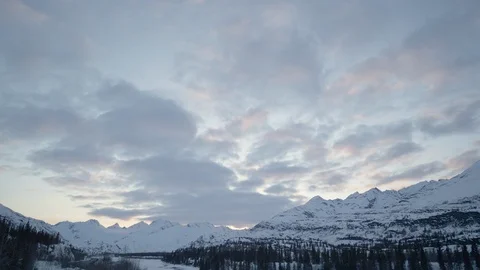 Time-lapse of clouds floating over snowy mountains at sunset Видео 113260379