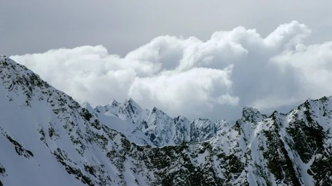 Time-lapse of clouds floating over snowy mountains Stock Footage 113262137