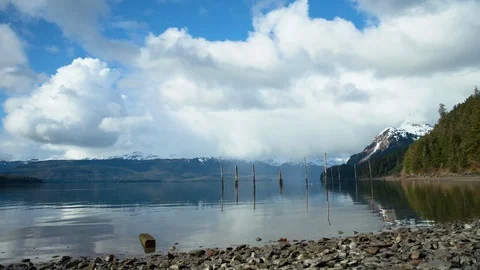 Time-lapse of clouds floating over a rippling lake and snowy mountains Stock Footage 113262788