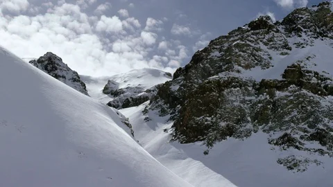 Time-lapse of clouds floating over snow-covered mountains Stock Footage 116786071