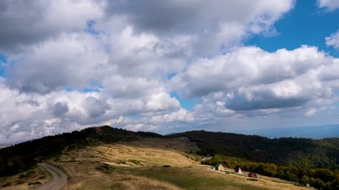 Time lapse of clouds flowing across the blue sky over the tops of the mountains Stock Footage 126065228