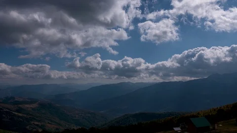 Time lapse of clouds flowing across the blue sky over the tops of the mountains Stock Footage 126065323