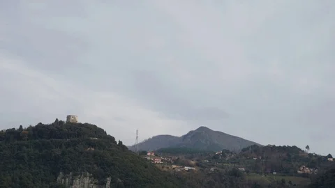 Time lapse of the clouds flowing over a hill with a castle Stock Footage 124013821