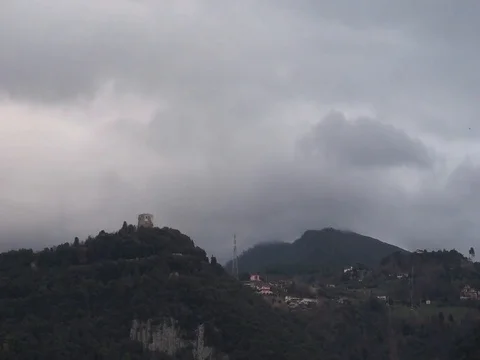 Time lapse of the clouds flowing over a hill with a castle Stock Footage 124013887
