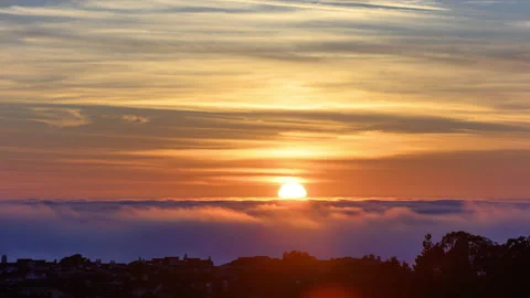 Time lapse of clouds flowing past housing along the coast Stock-Footage 158396801