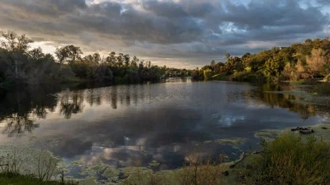 Time Lapse of Clouds Heading Over A Forested Lake Stock Footage 278532324