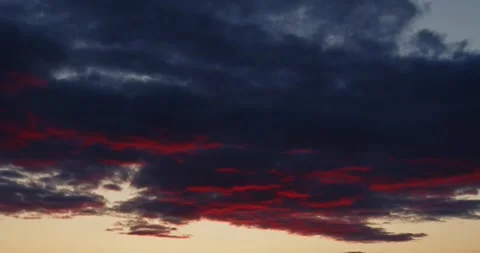 Time lapse clouds illuminated by the orange light sun setting over the horizon Stock Footage 278907834