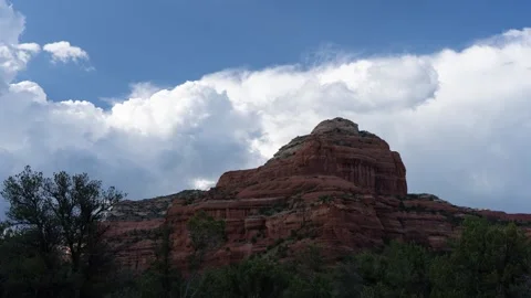 Time lapse of clouds, light, and shadows moving across a sandstone butte Stock Footage 248909646