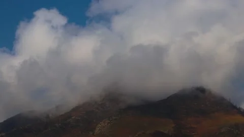 Time-lapse: Clouds move over mountain peaks in the light of the evening sun. Stock Footage 165274117