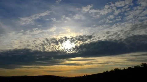Time lapse: Clouds moving above a rural landscape, eye of light in darkening sky Stock Footage 96353806