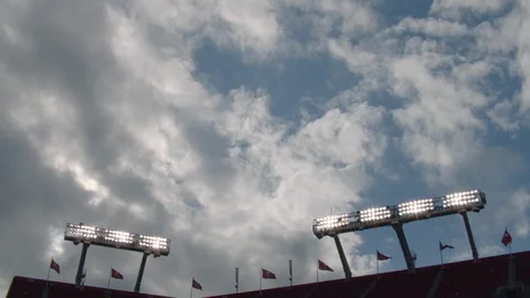 Time-lapse of clouds moving above illuminated lights and stadium Stock Footage 104772779