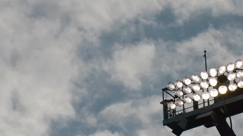 Time-lapse of clouds moving above illuminated stadium lights Stock Footage 104772847