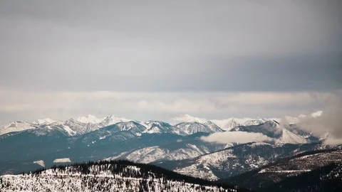 Time-lapse of clouds moving above snow capped mountains Stock Footage 116739202