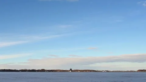 Time lapse of clouds moving above a snowy farm field with grain elevators  Stock Footage 224107317