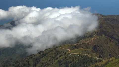 Time lapse clouds moving along a mountain road near the upper border a forest Stock Footage 339554708