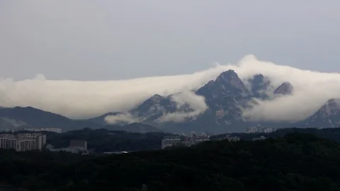 Time lapse of clouds moving around mountains Stock Footage 89923722