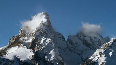 Time-lapse of clouds moving around snow capped peaks Stock Footage 116744795