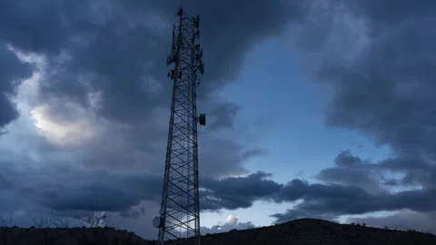 Time lapse of clouds moving beyond a communications tower at dusk Stock Footage 269948882