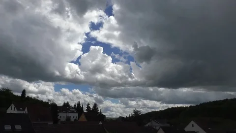 Time lapse of clouds moving in a blue sky above a small, rural German village Video stock 76783043