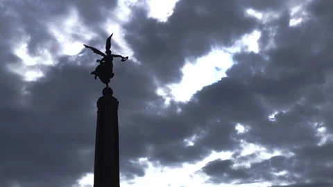 Time-Lapse of clouds moving in front of silhouetted statue of angel 1 Stock Footage 199038550