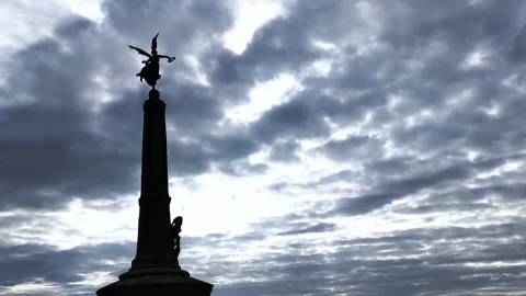 Time-Lapse of clouds moving in front of silhouetted statue of angel 2 Stock Footage 199099047