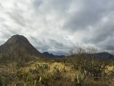 Time lapse of clouds moving over a small mountain on a desert ranch Stock Footage 72686713