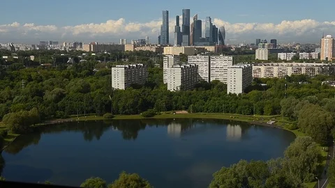 Time lapse of clouds moving over city skyline small pond in front of building 스톡 동영상 79995683