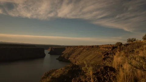 Time-lapse of clouds moving over the river and rocky region at sunset Stock Footage 87478084