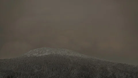 Time-lapse of clouds moving over the snow covered mountain and forest at sunset Stock Footage 87478858