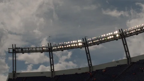 Time-lapse of clouds moving over flood lights and American football stadium Stock Footage 104770607