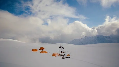 Time-lapse of clouds moving over a campsite on a snow covered mountain Видео 113249526