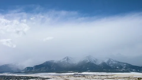 Time-lapse of clouds moving over a snow covered mountain range Stock Footage 113265430