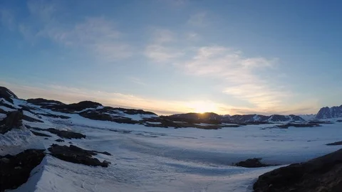 Time-lapse of clouds moving over a snow covered rocky landscape at sunset Stock Footage 113268609
