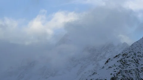 Time-lapse of clouds moving over the snow covered mountain Stock Footage 116749281