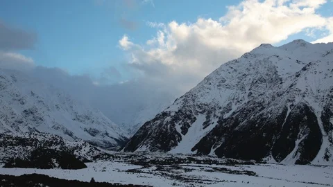 Time-lapse of clouds moving over the snowy mountain ranges Stock Footage 116749853