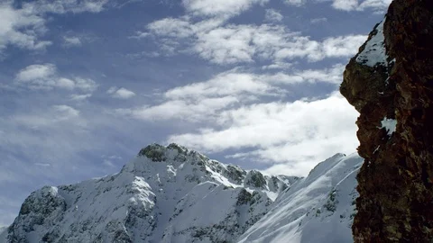 Time-lapse of clouds moving over snow-covered mountains Stock Footage 116786061
