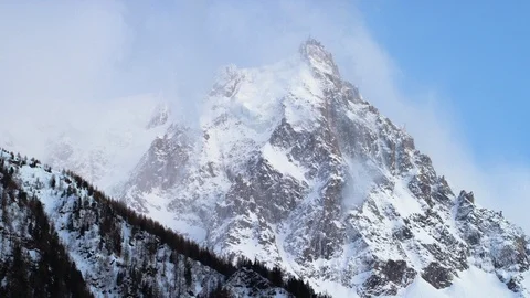 Time-lapse of clouds moving over the snowy mountain at sunset Stock Footage 116789339